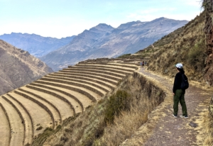 woman walking near agricultural terraces in Cusco, Peru