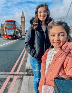 two world schoolers kids in front of Big Ben and bus in London, England