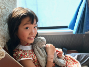 girl with a stuffed animal in China on a bus