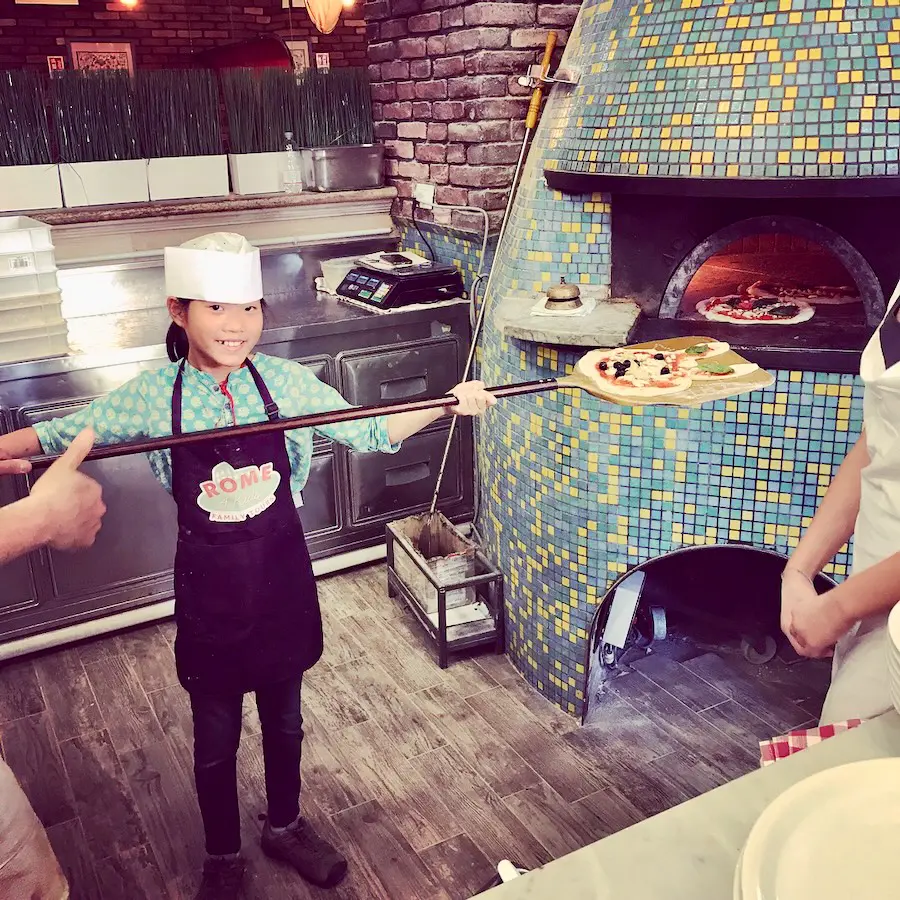 girl working near a pizza oven in italy