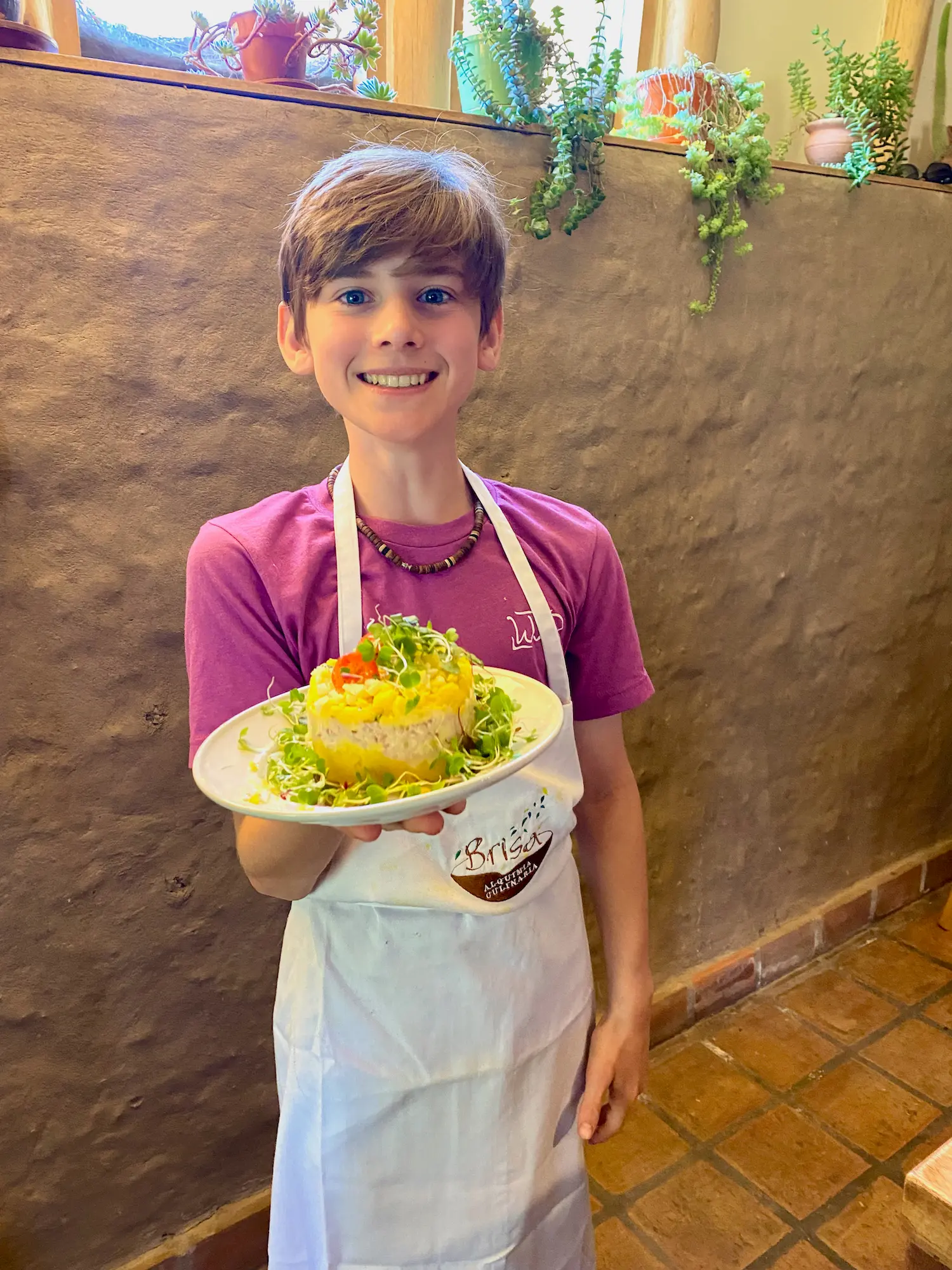 child in a worldschooling cooking class holding dish that they made