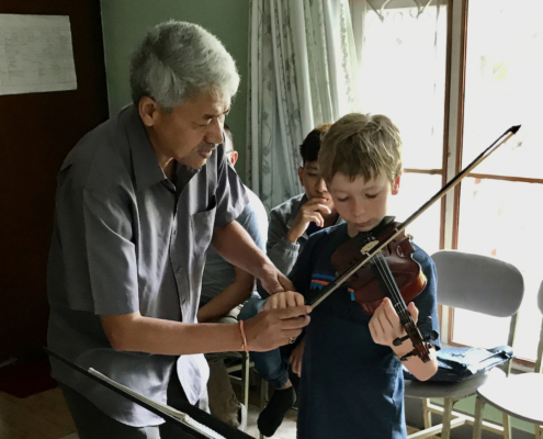 music and worldschooling, boy iwth violin